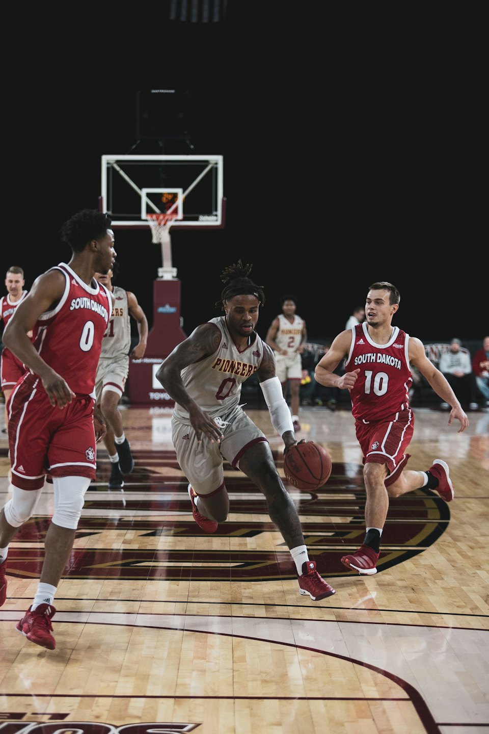 Basketball players compete during a game on an indoor court.