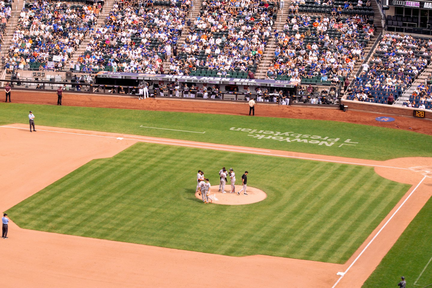 Baseball players on a field during a game with a stadium crowd.