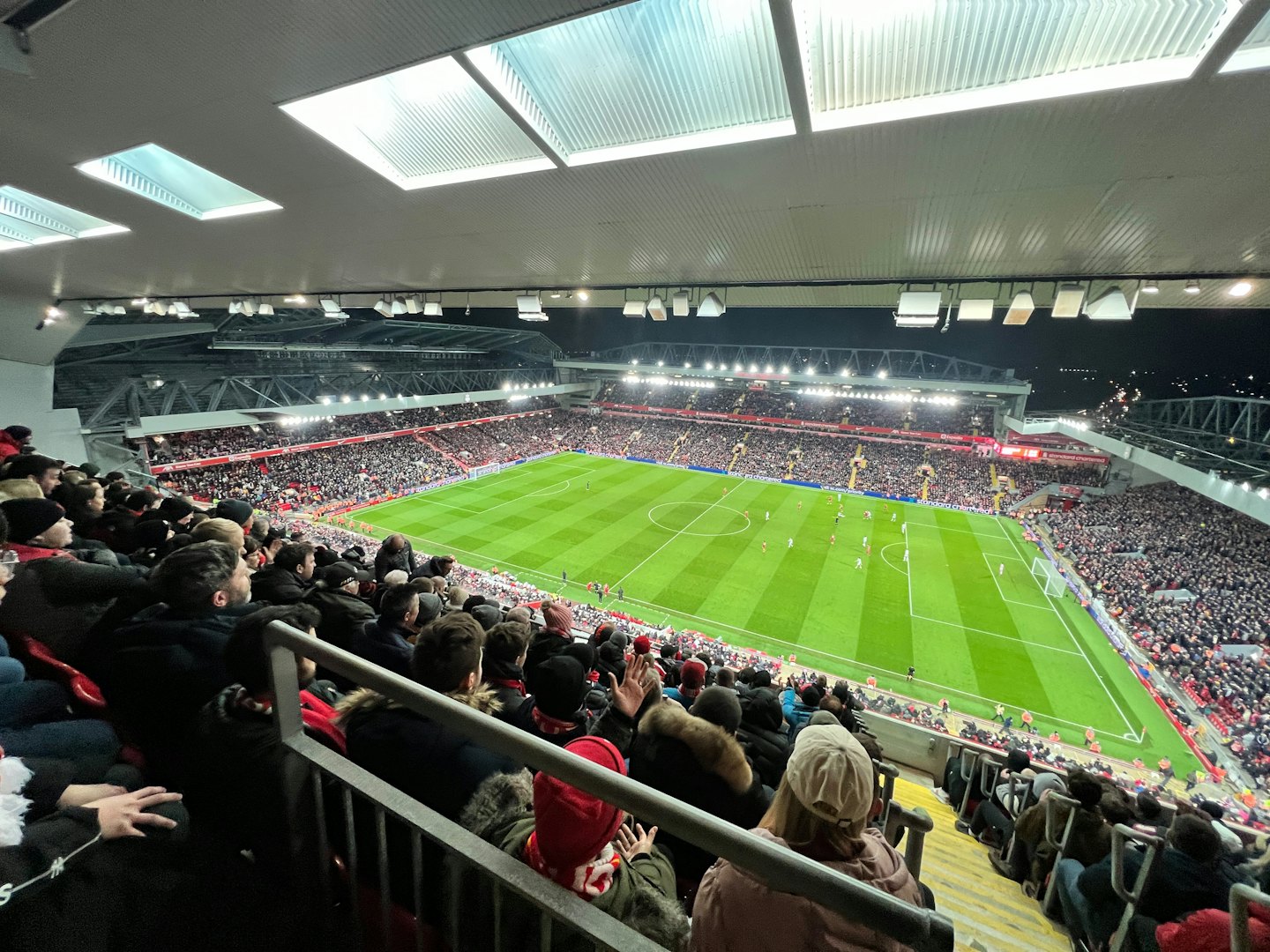Spectators watch a football match at a modern stadium.